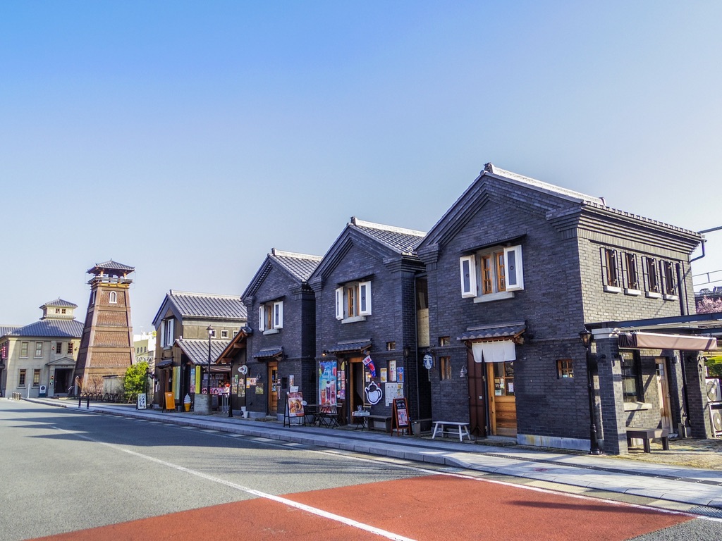 黒煉瓦の店舗が連なる甲州夢小路の街並みと遠景の時の鐘