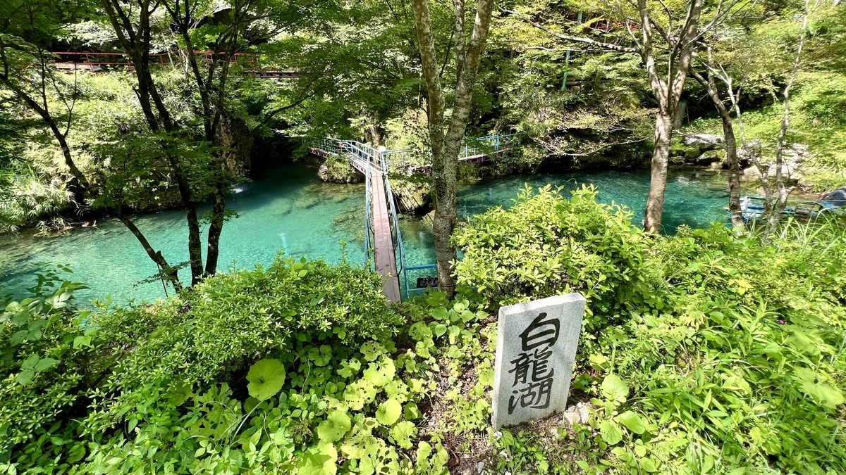 白龍湖に到着。エメラルドグリーンの湖と吊り橋が見える