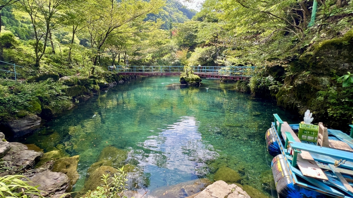 白龍湖の湖面に浮かぶボートと吊り橋のある幻想的な風景