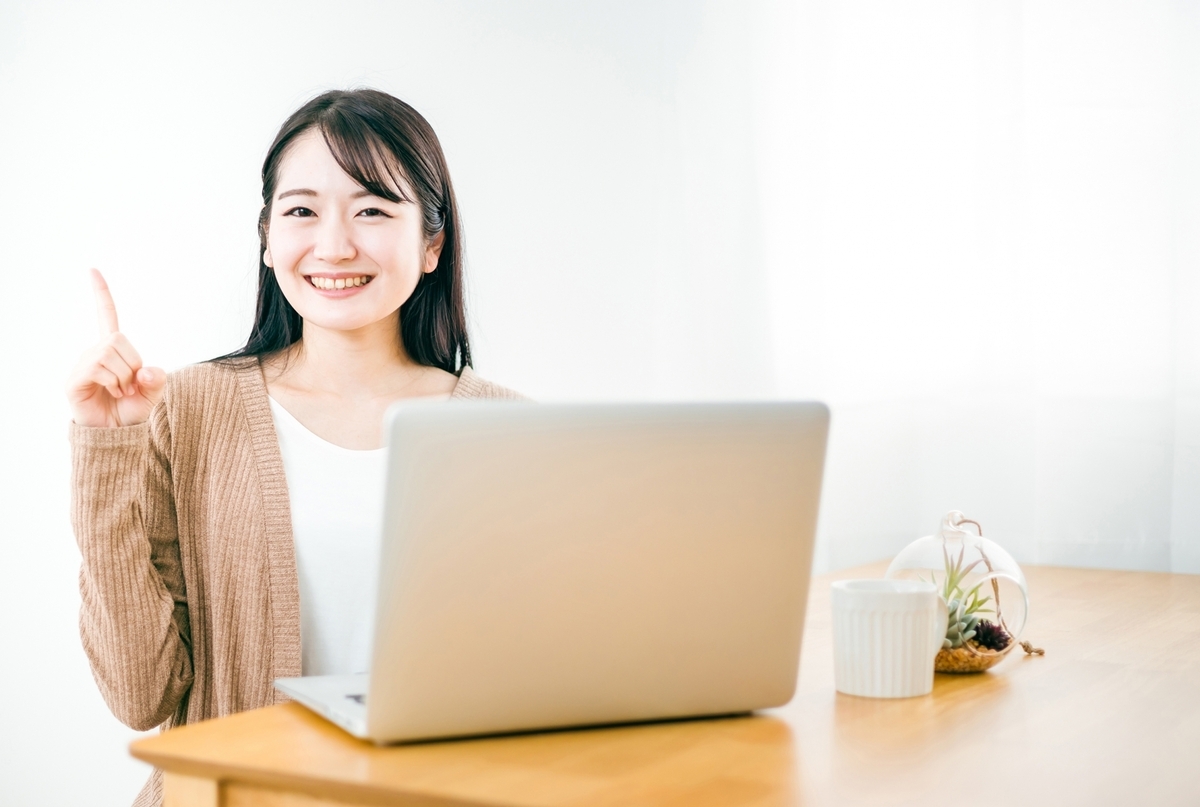 노트북을 열고 이쪽을 웃으며 바라보는 여성