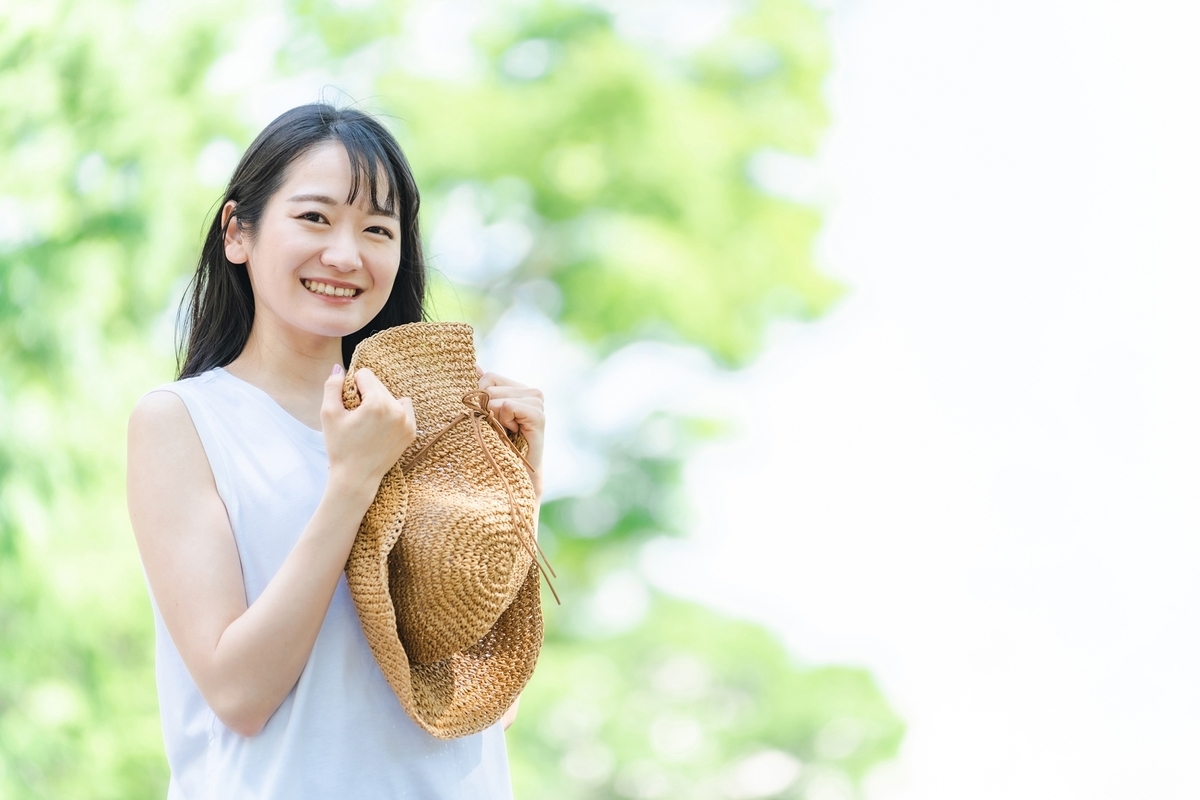 밀짚모자를 들고 미소 짓는 여성