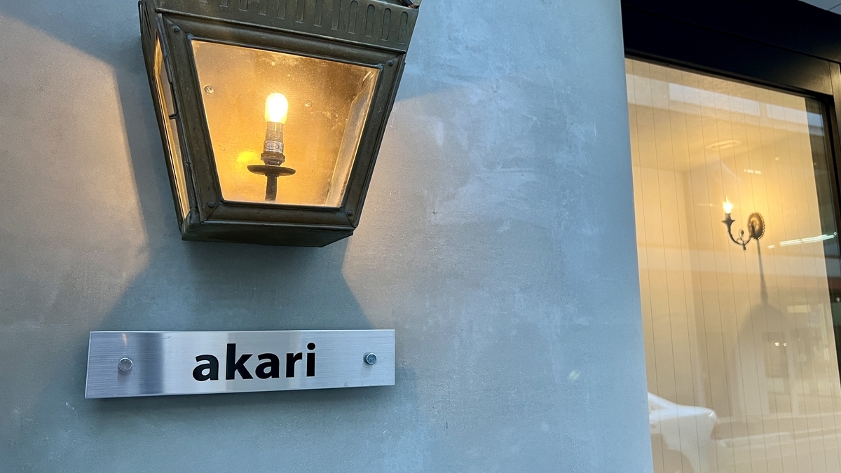 akari's name logo and exterior wall illuminated by lights