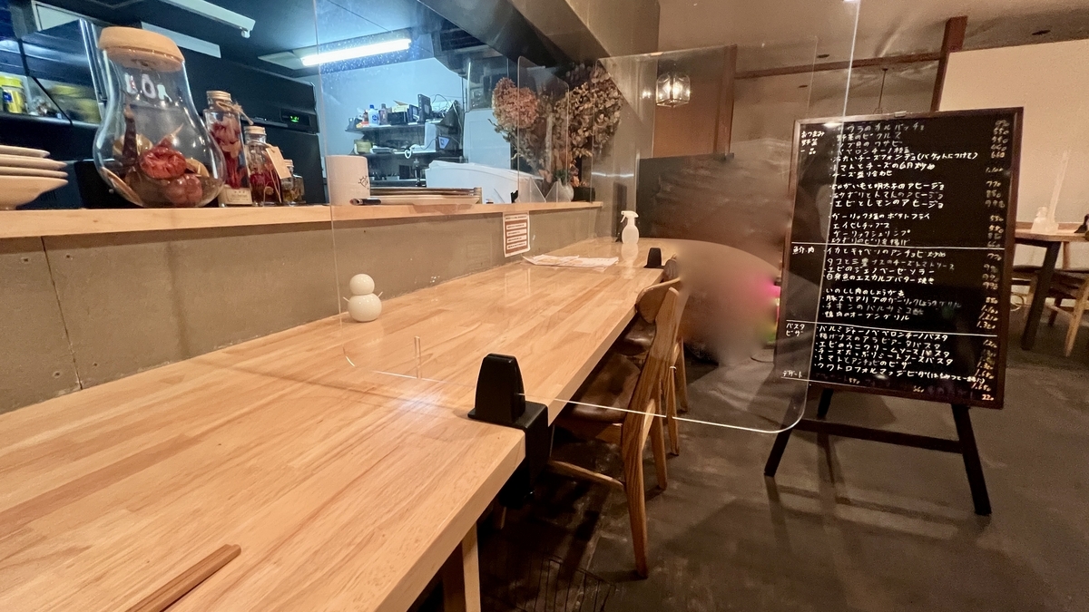 Counter seating and handwritten menu on a chalkboard inside the restaurant