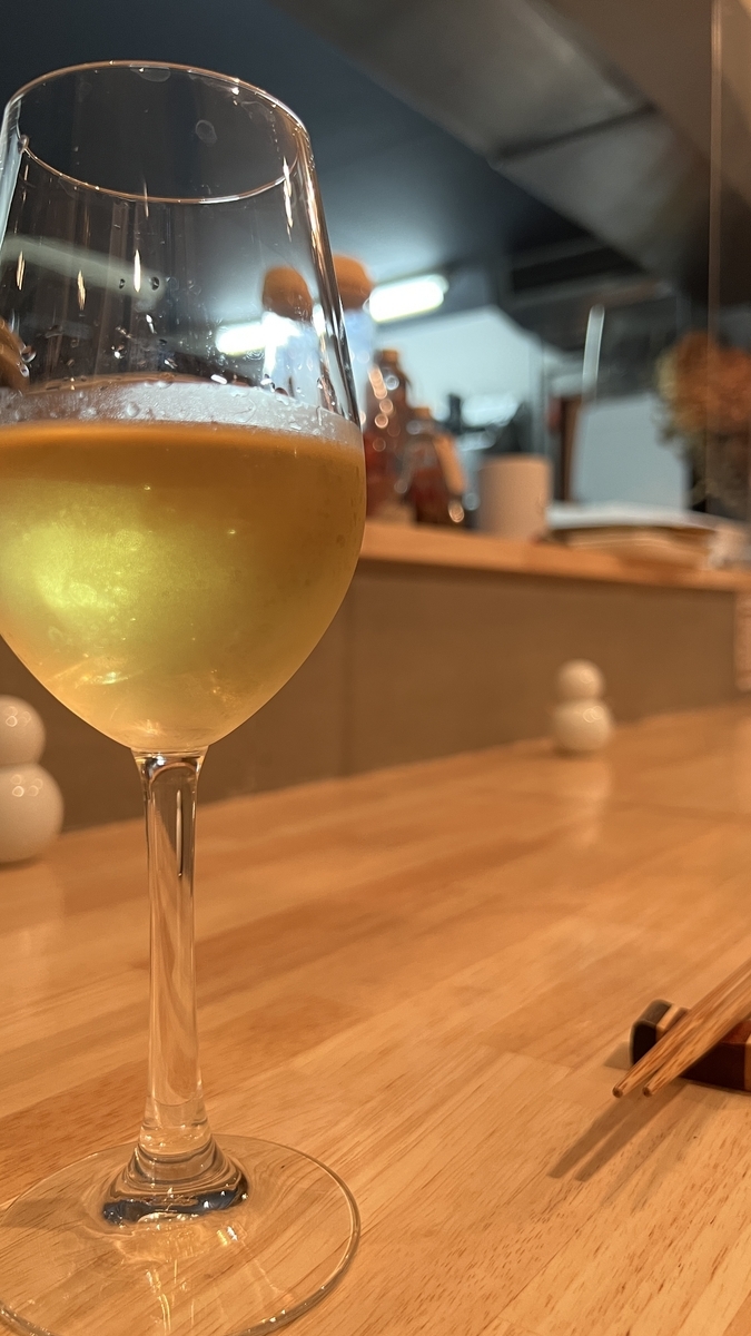 Wine-filled glass on the counter with a view of the kitchen in the background