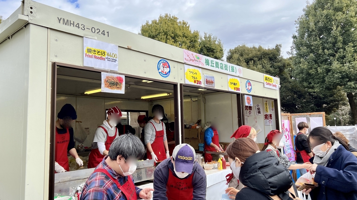 Staff in red aprons cooking at a popular food stall