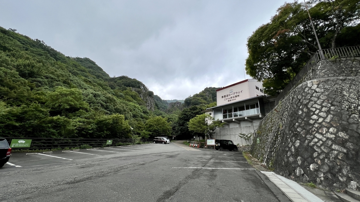 Parking area and station building at Kōuntei Station, surrounded by mountains