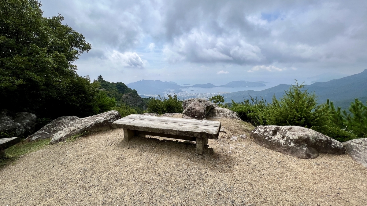 木制长椅和岩石地面上展现的群山和濑户内海景色