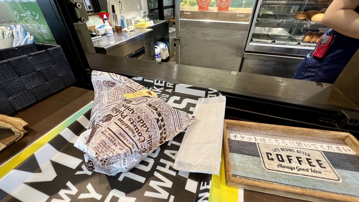 用包装纸包着的橄榄猪肉汉堡和店铺柜台