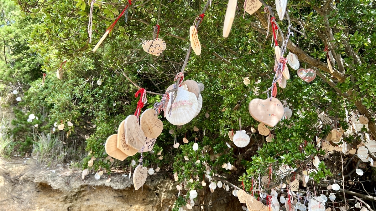 Ema with written wishes displayed among green trees
