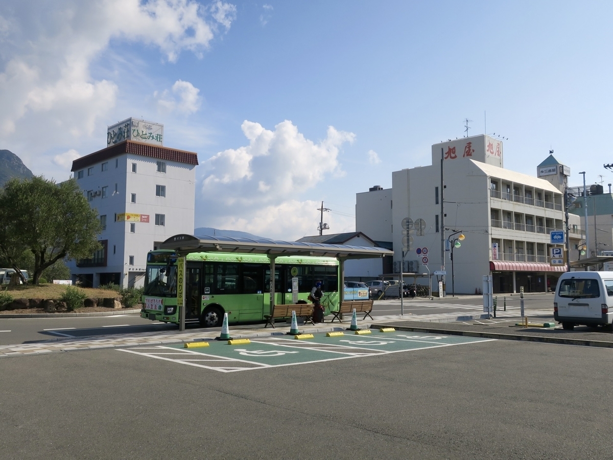 バス停留所に停車しているオリーブバスと小豆島の公共施設が写る穏やかな風景