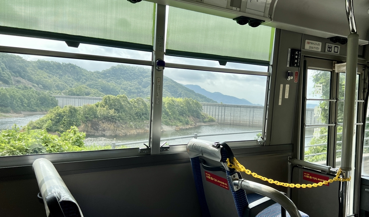 View of the Uchiumi Dam and lush greenery from the bus window.