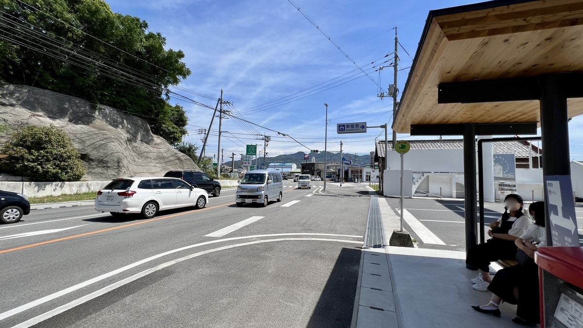 Sign at Kusakabe Port bus stop and sloped road beyond.