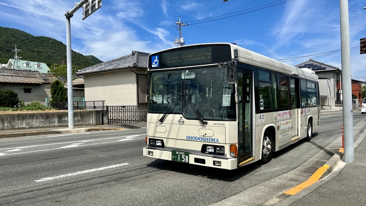 South Loop Fukuda Line bus stopped on the road with mountain backdrop.