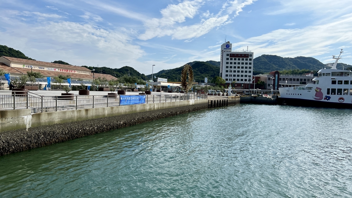 Tonosho Port waterfront and buildings with scenic backdrop.