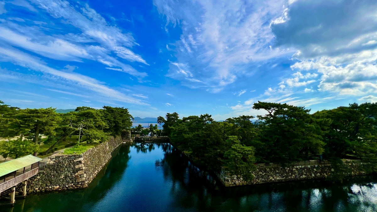 ทิวทัศน์ปราสาททาคามัตสึที่ท้องฟ้าใสและคูน้ำกลมกลืนอย่างสวยงาม