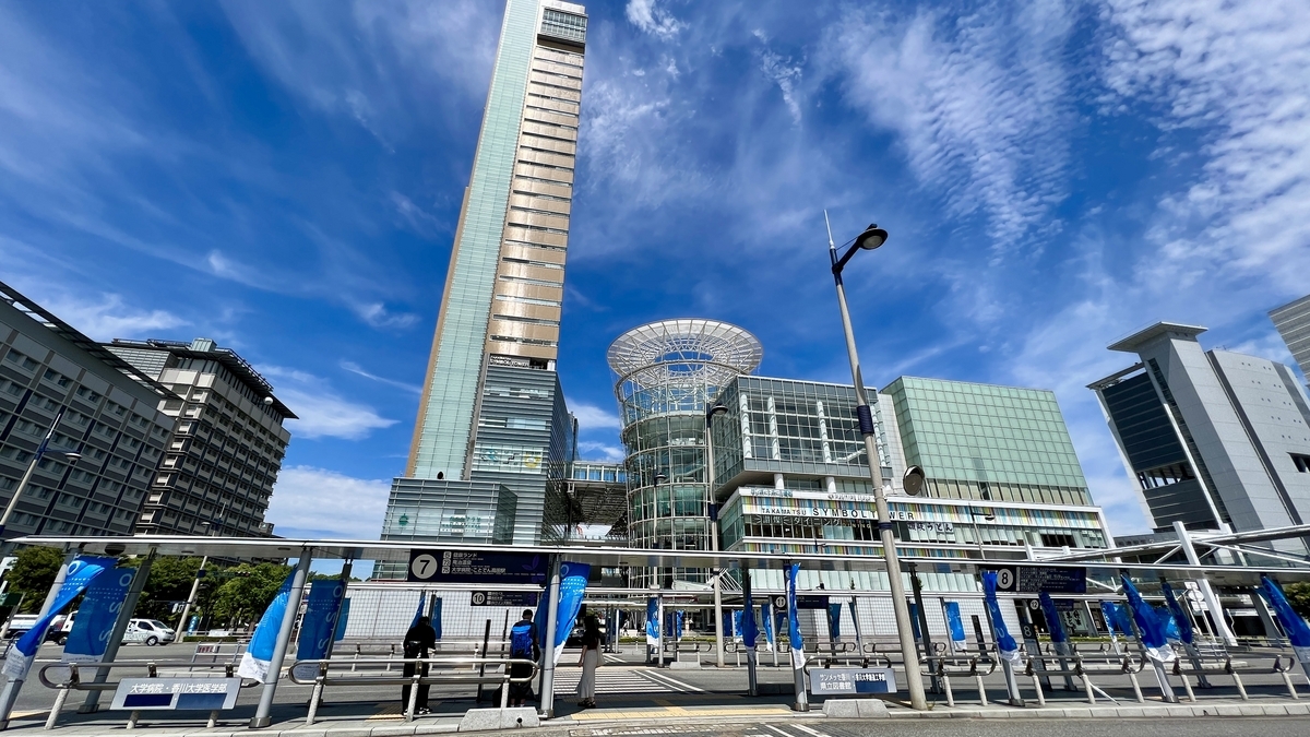 วิวกว้างของวงเวียนรถบัสหน้าสถานี Takamatsu พร้อมตึกสูงในฉากหลัง