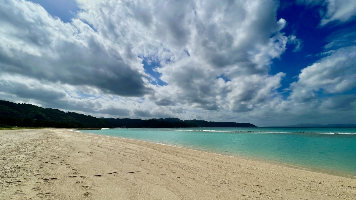雲朵滿天的天空下無人的寧靜鏡地海灘海岸線