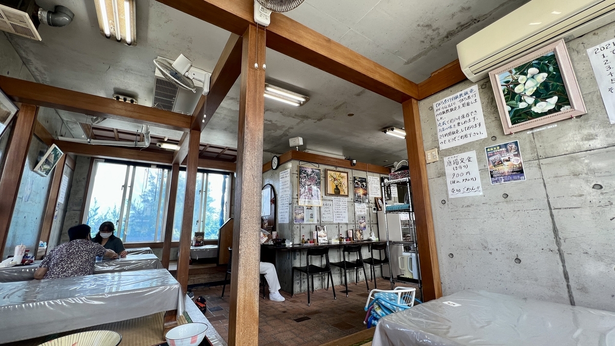 Clean and airy table seating with natural light from large windows at Yoshimi Shokudo