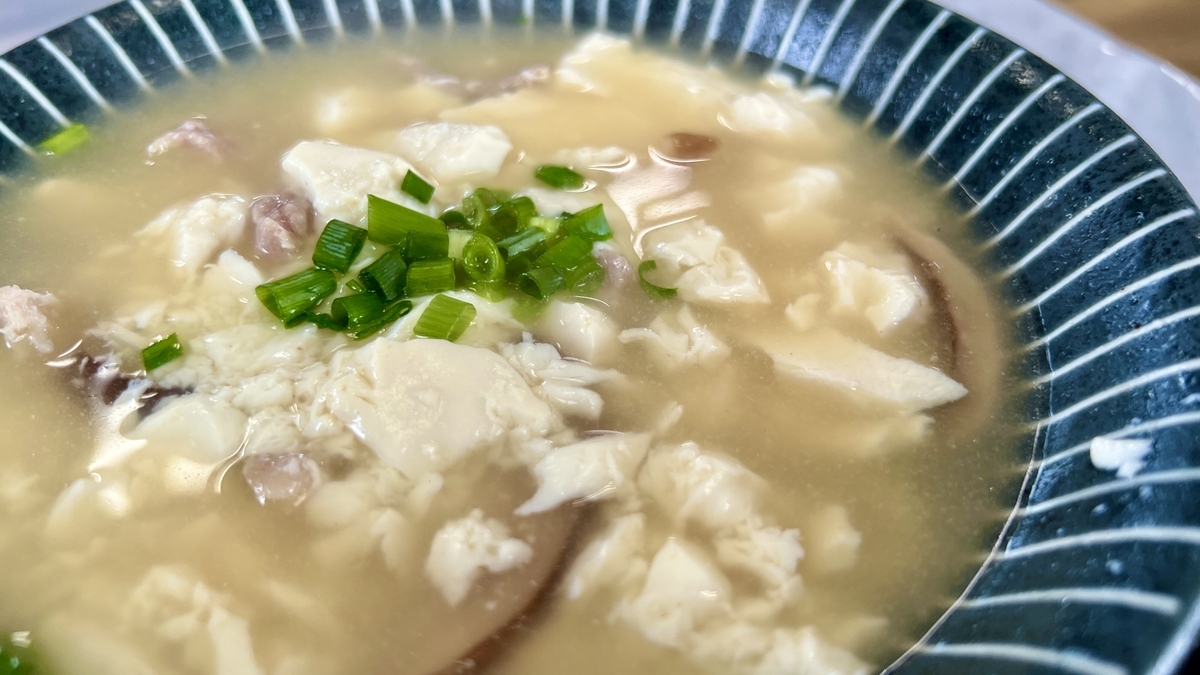 Yushi tofu soup with tofu and egg floating gently in broth