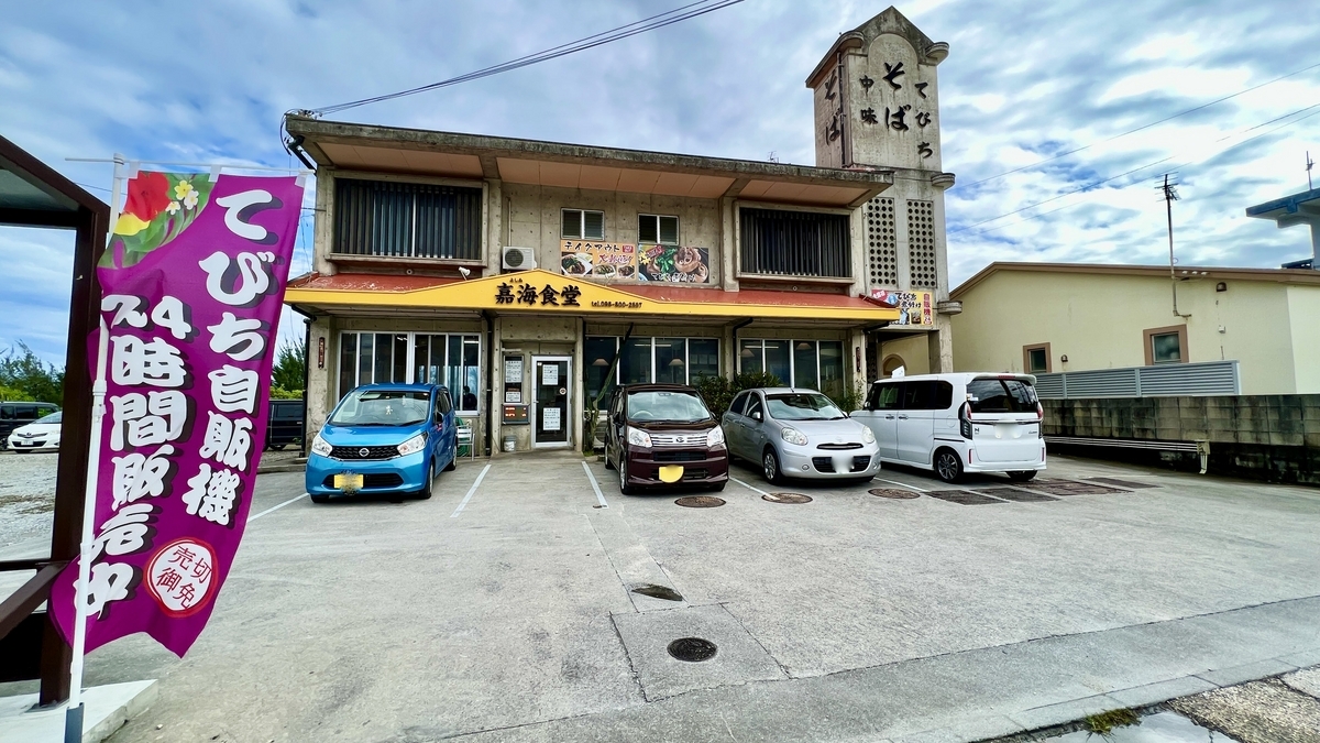 Exterior of Yoshimi Shokudo with parking lot and tebichi stew flags by the entrance