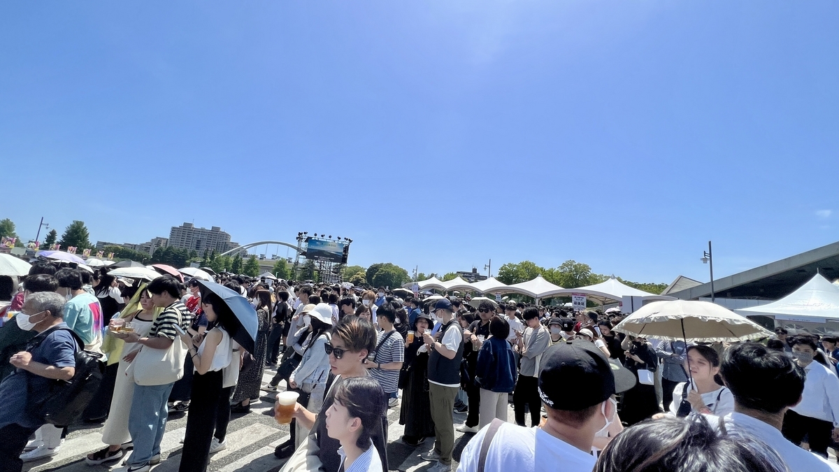 Visitantes esperando en largas filas bajo el fuerte sol en el Craft Gyoza Fes Tokio
