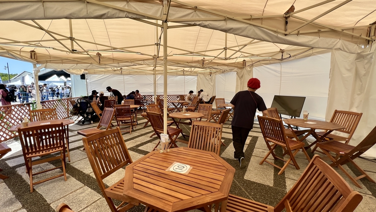 Interior del Craft Gyoza Lounge con mesas y sillas de madera bajo una carpa