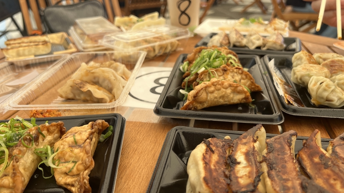 Mesa llena de bandejas con diferentes gyozas de varios restaurantes