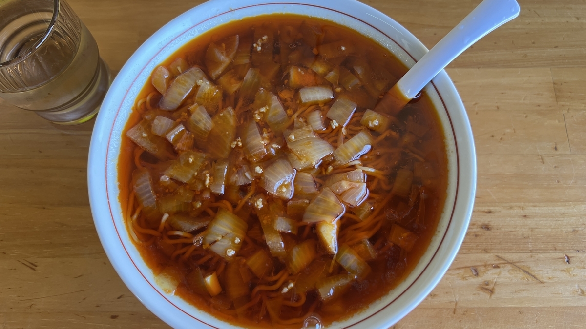 ภาพระยะใกล้ของ Katsuura Tantanmen ร้าน Harada น้ำซุปสีแดงและหัวหอมจำนวนมาก