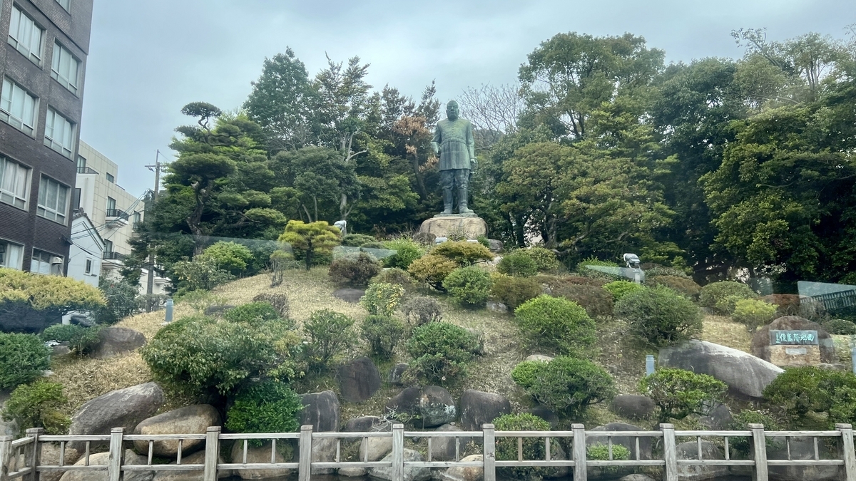 버스 창문 너머로 보이는 사이고 다카모리 동상과 녹음이 짙은 주변 풍경