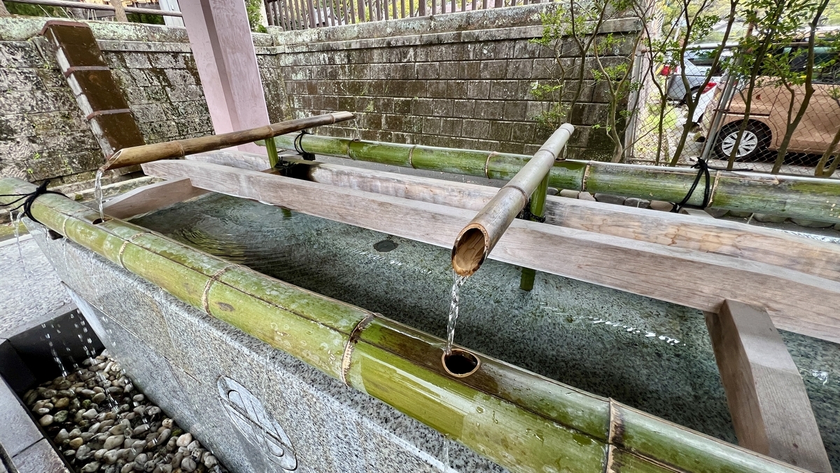 กระบวยน้ำและผิวน้ำสะท้อนแสงที่บ่อน้ำชำระร่างกายของศาลเจ้าเทรุกุนิจินจะ