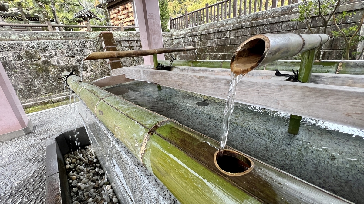 หลังคาของบ่อน้ำชำระล้างร่างกายล้อมรอบด้วยต้นไม้ภายในศาลเจ้าเทรุกุนิจินจะ