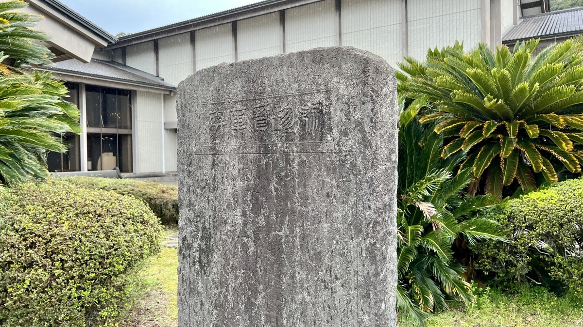 Close-up view of the Shuuchin Houkohi monument with the Reimeikan building in the background