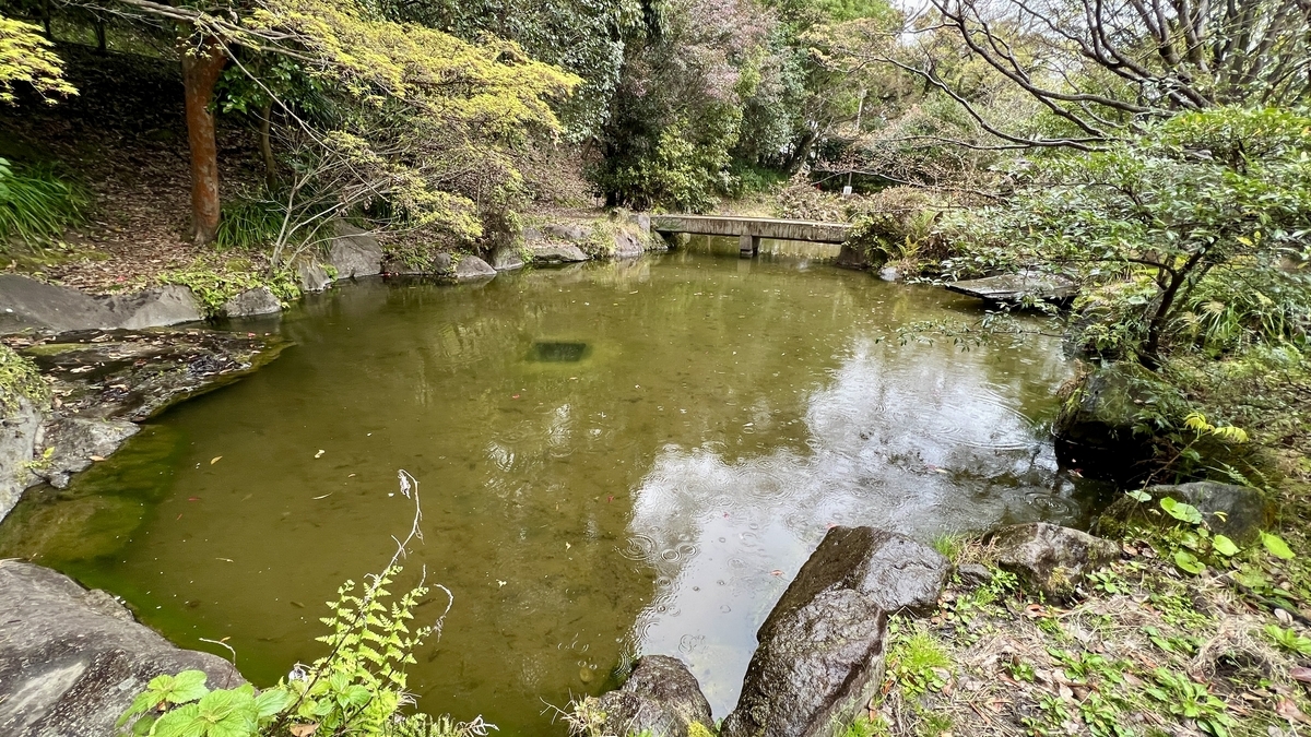 Serene view of Miike Pond and Kyukobashi bridge in harmony within the Reimeikan Garden