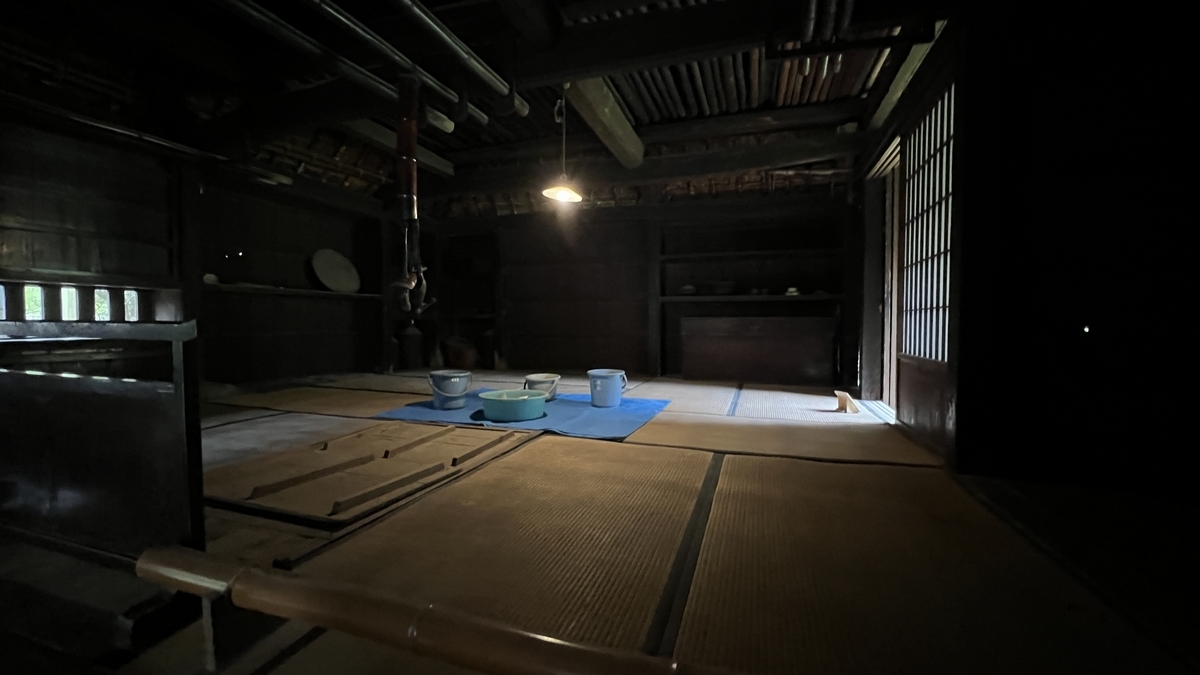 Inside view of Tenoma Futatsuya showing the hearth and wooden beams under the roof