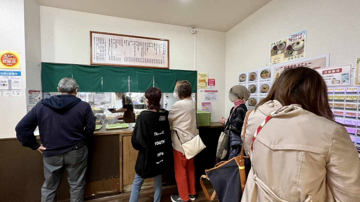 Clientes esperando su turno frente al mostrador en Toyokichi Udon JR Miyazaki Station