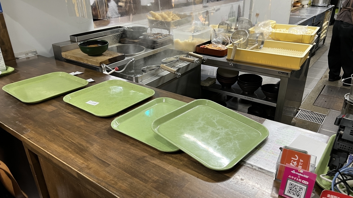 Cliente entregando su ticket al personal en el mostrador junto a la cocina