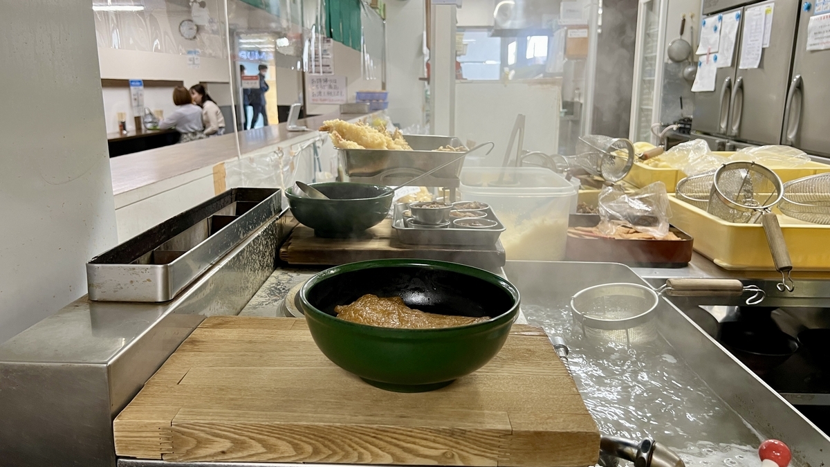Escena en la cocina con vapor y ollas de fideos hirviendo en Toyokichi Udon