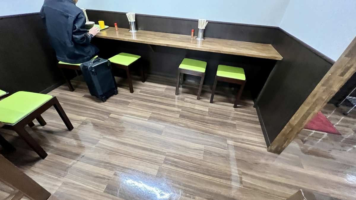 Área de mesas y suelos de madera dentro de Toyokichi Udon JR Miyazaki Station