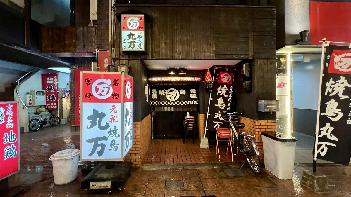 宫崎地鸡烤鸡腿老字号丸万的外观 夜晚的店门和招牌亮灯的样子