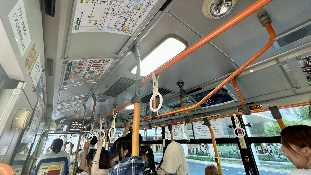 富士森公園行きのバス車内で座席と吊り革が並ぶ様子