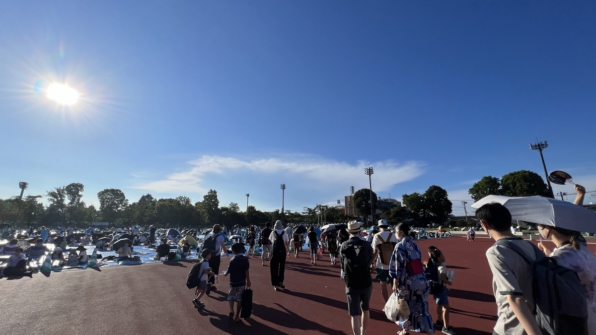 青いレジャーシートが敷かれ始めた富士森陸上競技場の観覧エリア