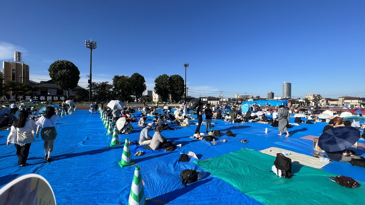 花火開始前の富士森陸上競技場で過ごす観客たち