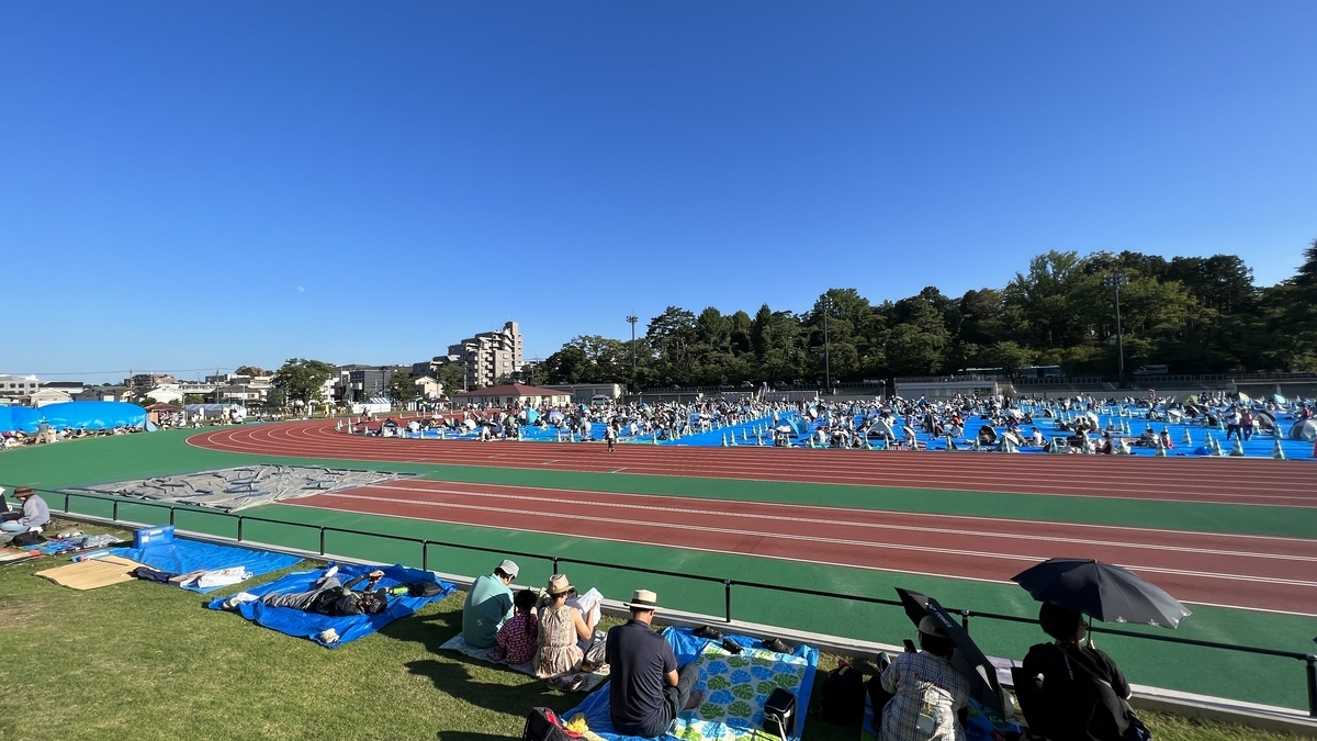 トラック外周の芝生エリアに座る観覧客