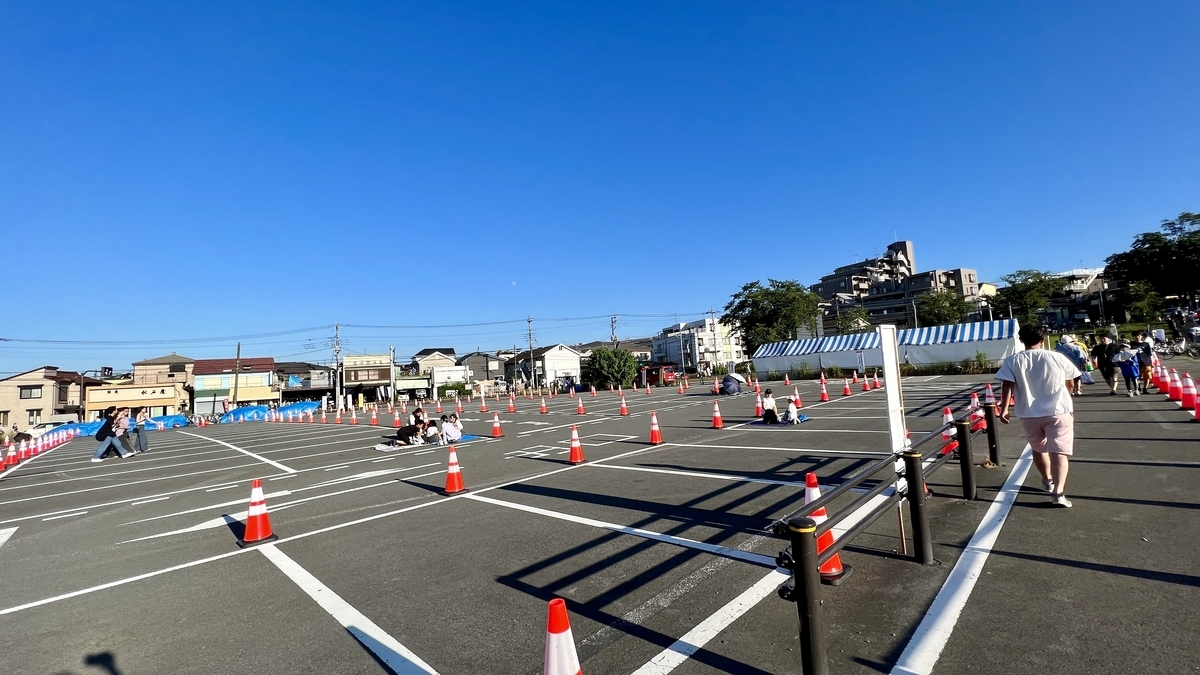 駐車場に区画が設けられ多くの人が集まる準備の様子