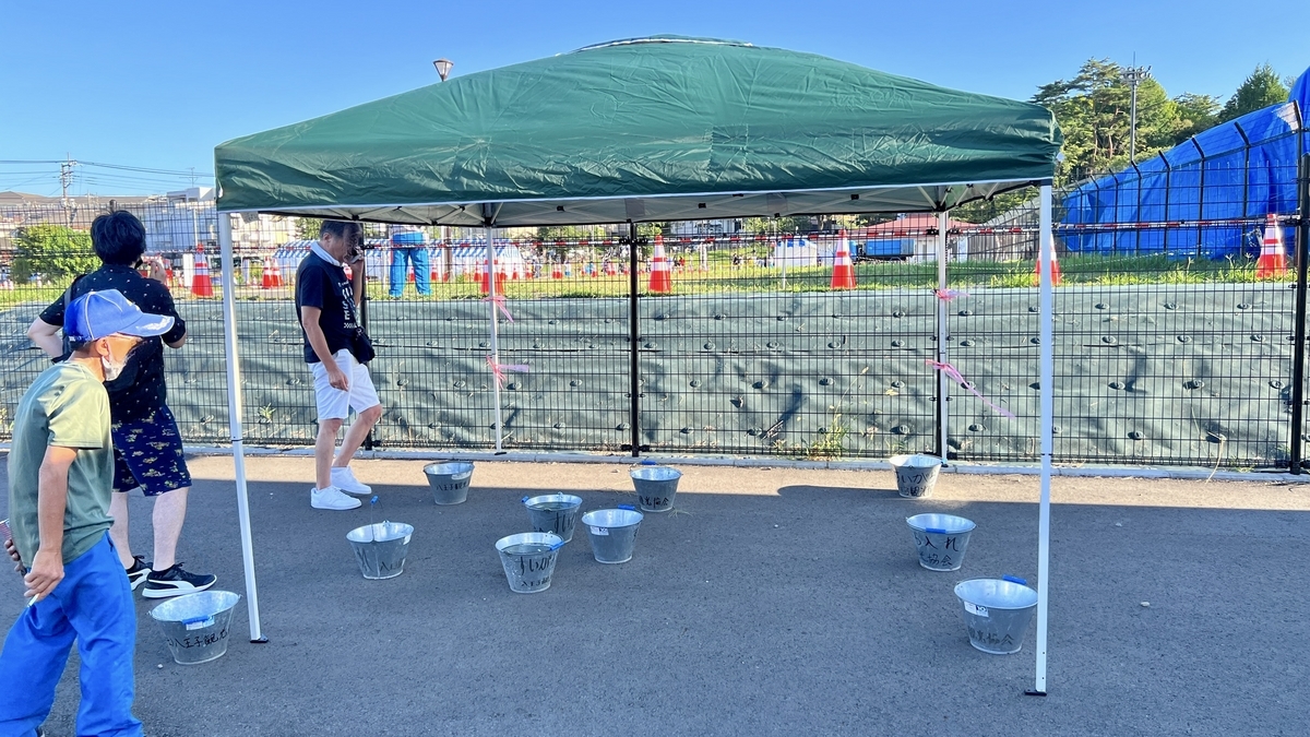 喫煙所テントと利用者が立ち寄る様子