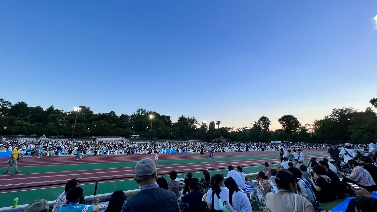 日が落ち始めた会場で花火の開始を待つ人々の様子
