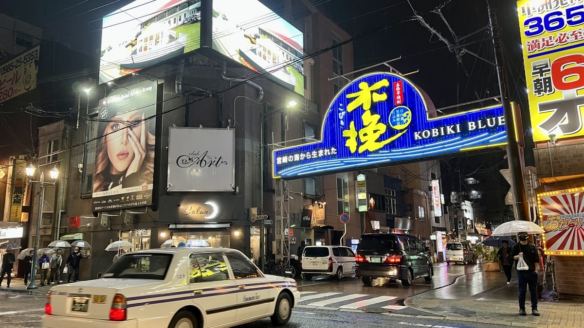 Night view of the southern entrance to Nishi-Tachibana Street with bright signs lining the busy street