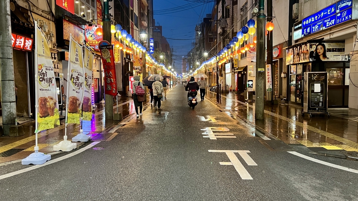 Nishitachi nightscape with bright lights reflecting on the wet street on a rainy night