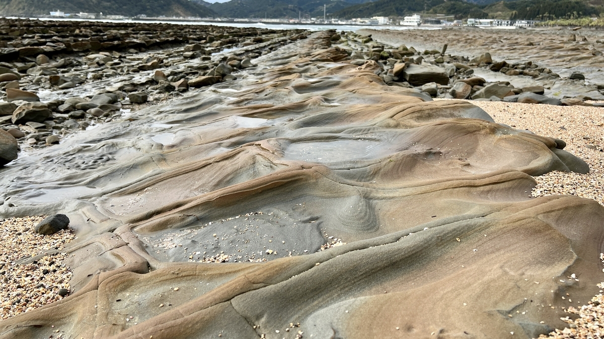 砂浜近くに広がる鬼の洗濯板の岩場が立体的に続く様子 自然が作り出した独特の地形