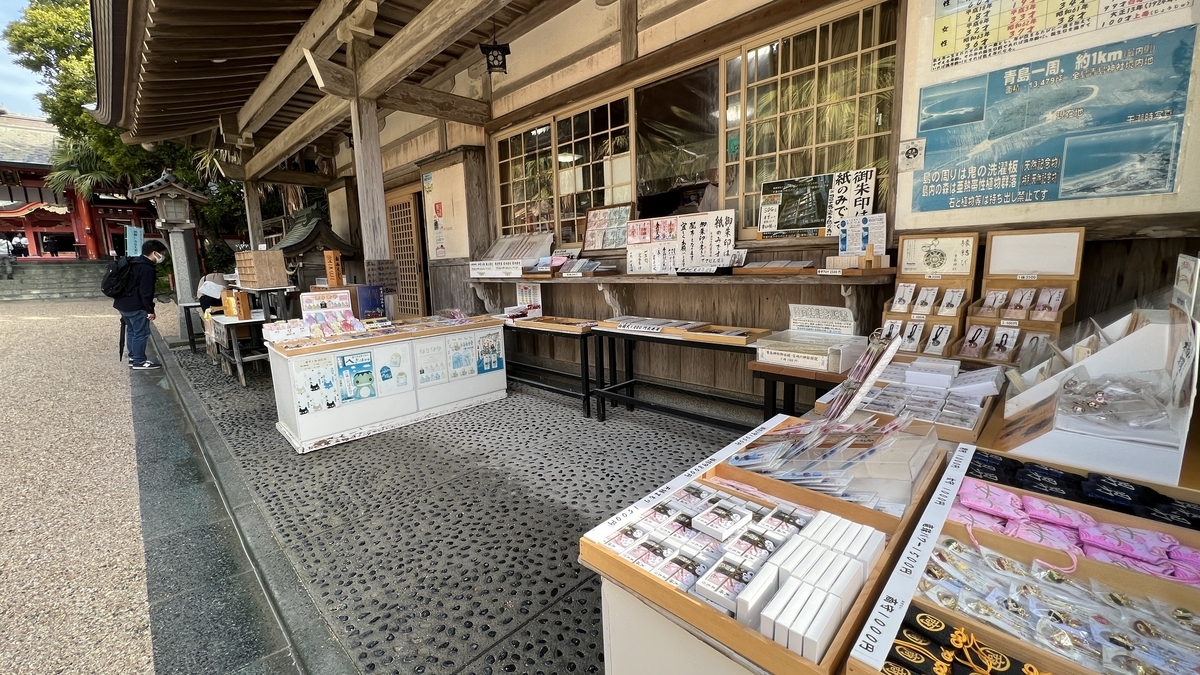 青島神社の社務所前に並ぶ御朱印やお守りの授与所 案内板と授与品の展示が見える